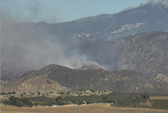 Smoke from the Wolf Fire rises above hills near Banning.
